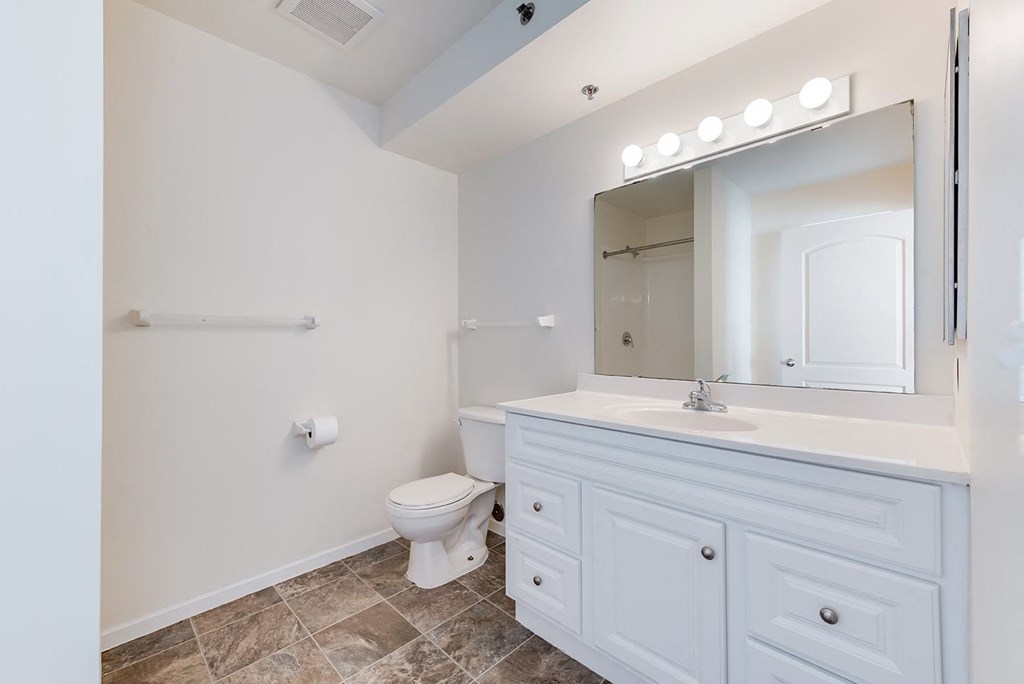 a white bathroom with a toilet and a sink