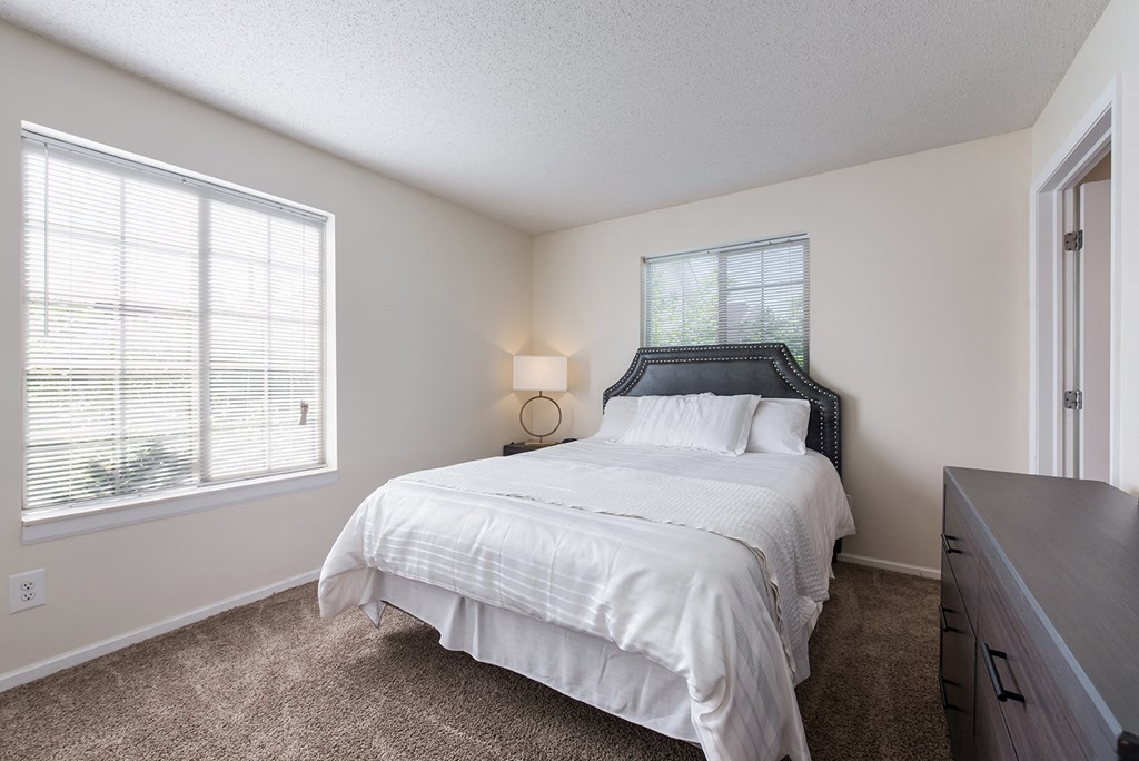 a bedroom with a bed and a dresser and a window