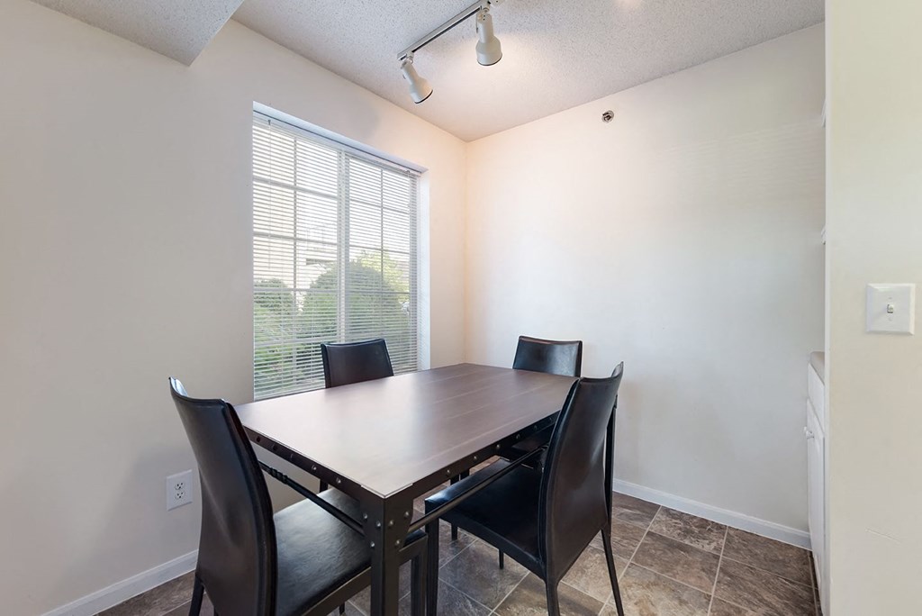a dining room with a large window and a table with chairs