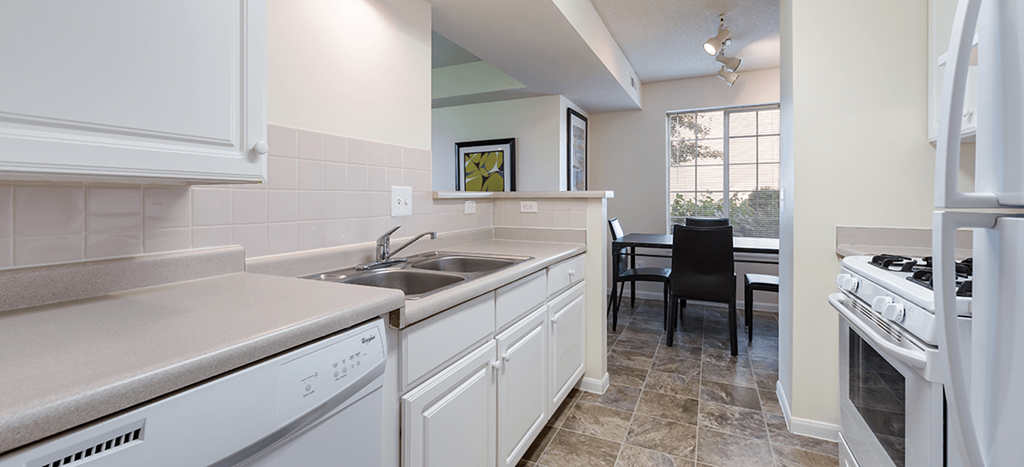 a kitchen with a sink and a stove and a dining room