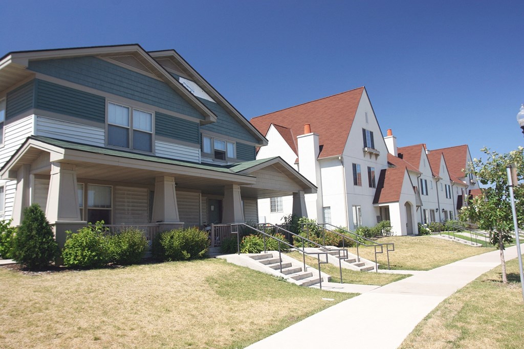 a row of houses on the side of a sidewalk