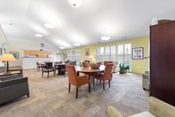 a clubhouse with a dining table and chairs and a kitchen at Horace Mann Apartments and Townhomes in Gary, IN