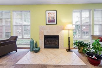 a community room with a fireplace and some windows at Horace Mann Apartments and Townhomes in Gary, IN