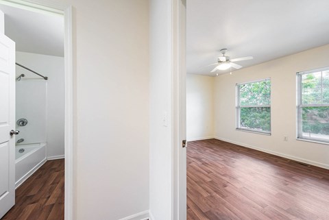 An empty bedroom and a doorway to a bathroom with a shower and toilet at Horace Mann apartments and townhomes in Gary, IN