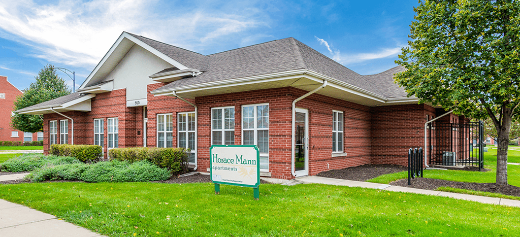 Horace Mann Apartments leasing office a red brick building with lush landscaping