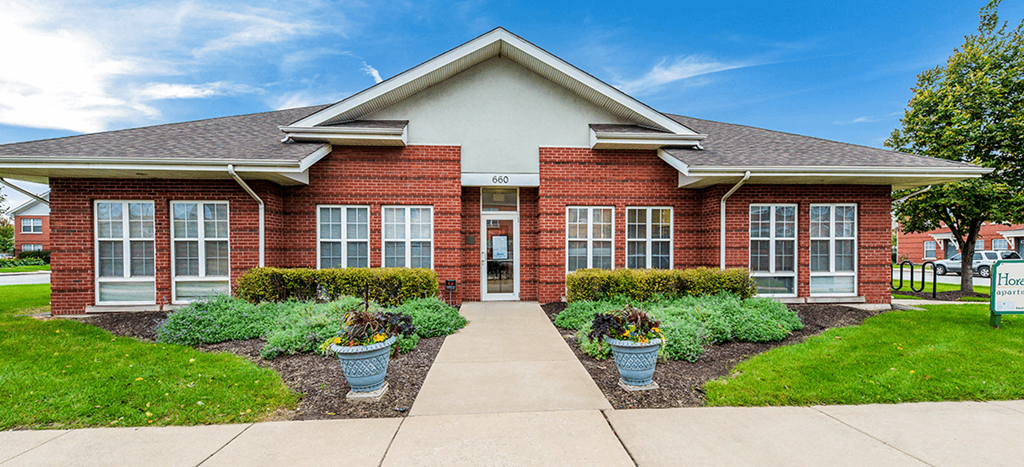 the front of a brick building with a sidewalk in front of it