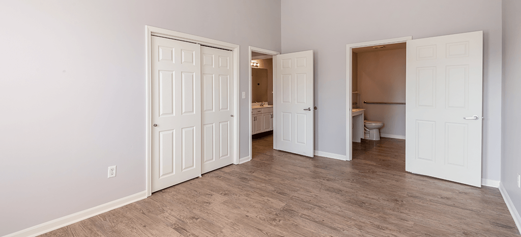 an empty bedroom with a closet and a bathroom