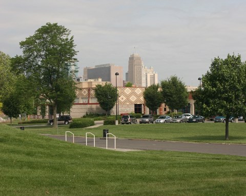 A park with a playground and a building in the background.