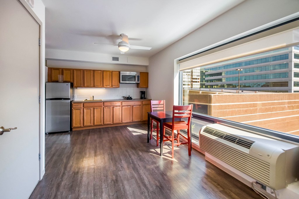 A kitchen with wooden floors and a table with chairs.