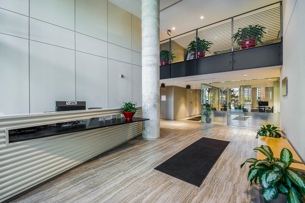 A modern office lobby with a black and white rug on the floor.
