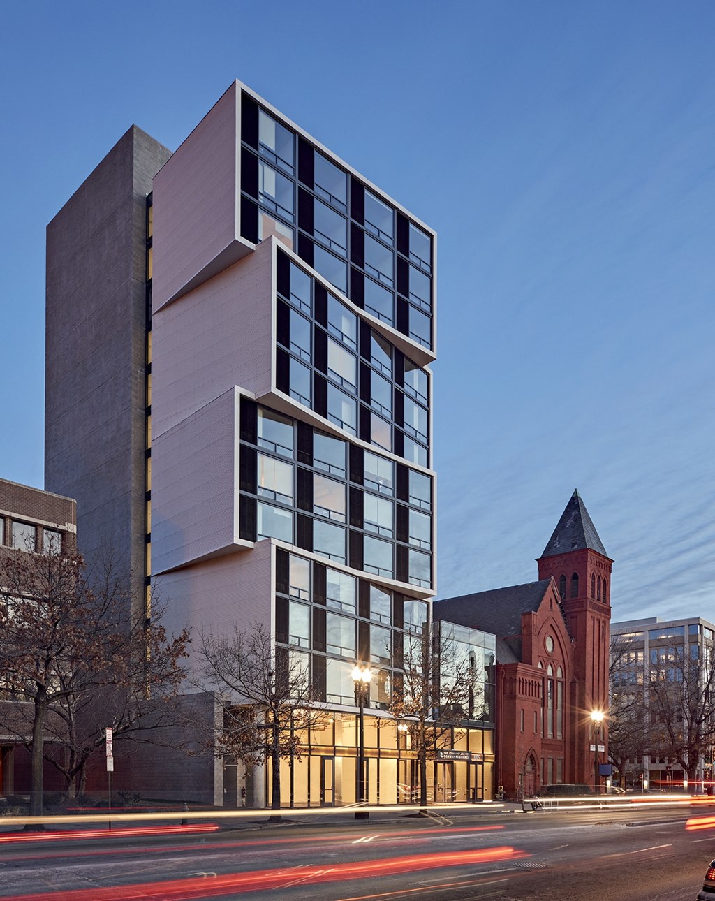 A modern building with a clock tower in the background.