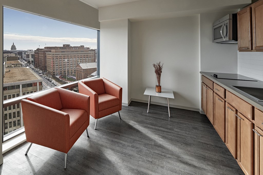 Two chairs and a table in a room with a view of the city.