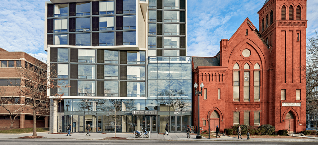 Ker Conway Apartments a glass building next to a red brick building on a city street