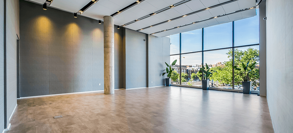 an empty room with a large window and wood flooring