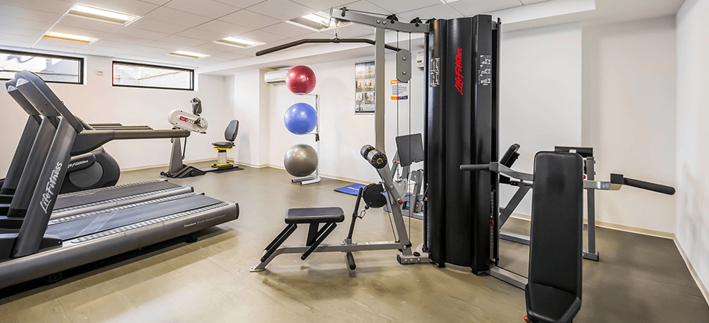 a gym with cardio equipment and weights in a building