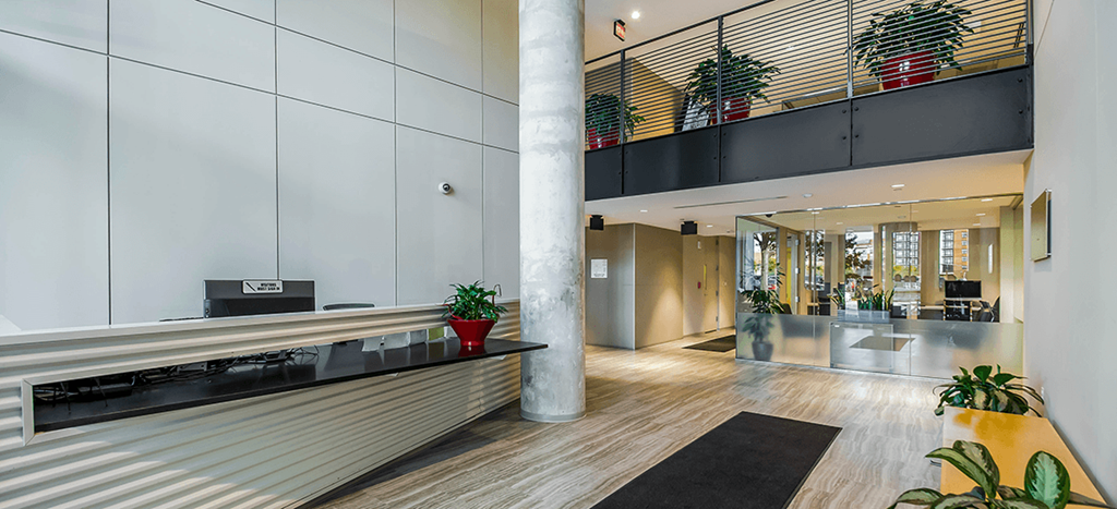 a lobby with a reception desk and a large pillar at Ker Conway Apartments