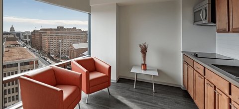a living room with two orange chairs and a view of the city