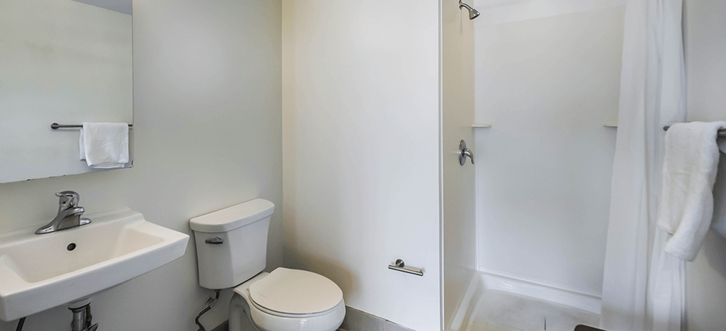 a bathroom with a toilet and a sink and a shower at Ker Conway Apartments