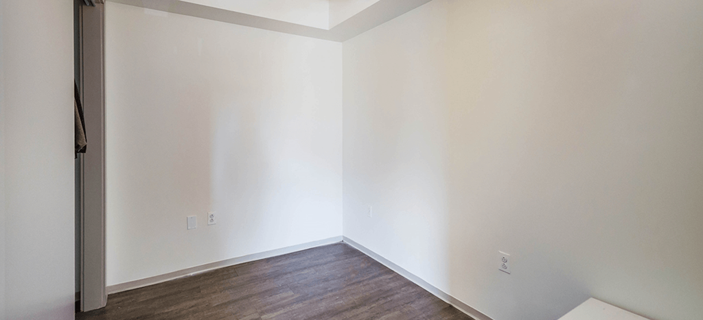a empty room with white walls and wood flooring at Ker Conway Apartments