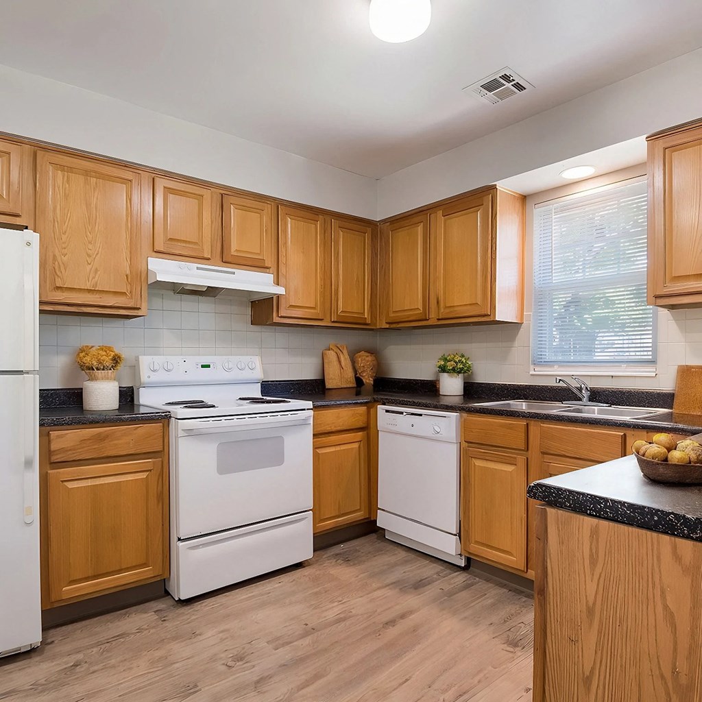 A kitchen with wooden cabinets and white appliances.
