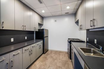 A kitchen with black countertops and stainless steel appliances.
