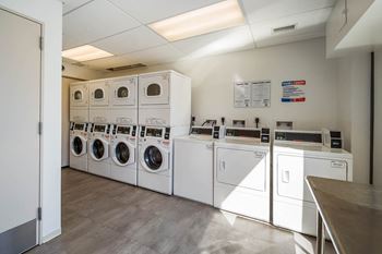 A laundry room with washing machines and dryers.
