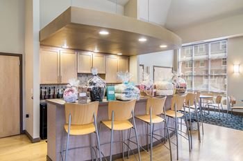 A modern kitchen with a bar area and chairs.