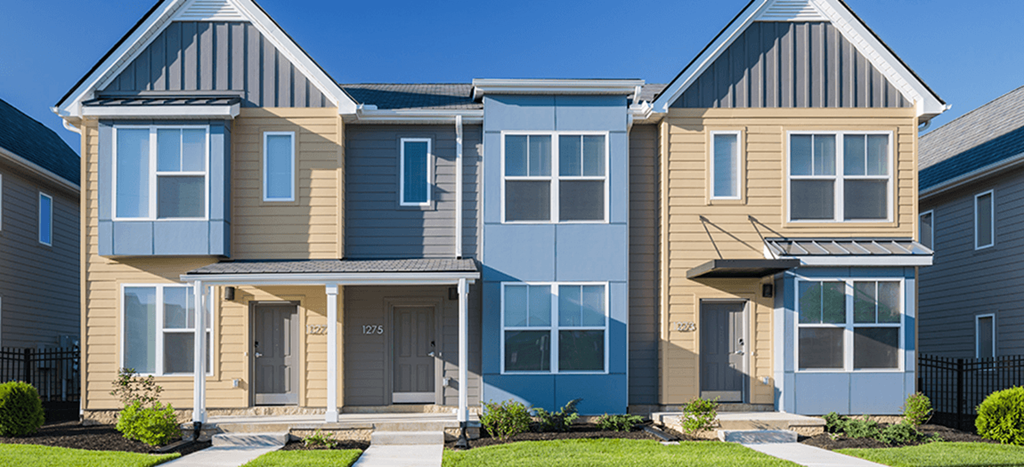 a row of townhomes with blue and brown siding at Legacy Pointe at Poindexter