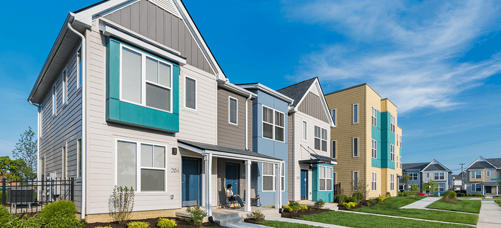 a row of townhomes with blue and white siding at Legacy Pointe at Poindexter