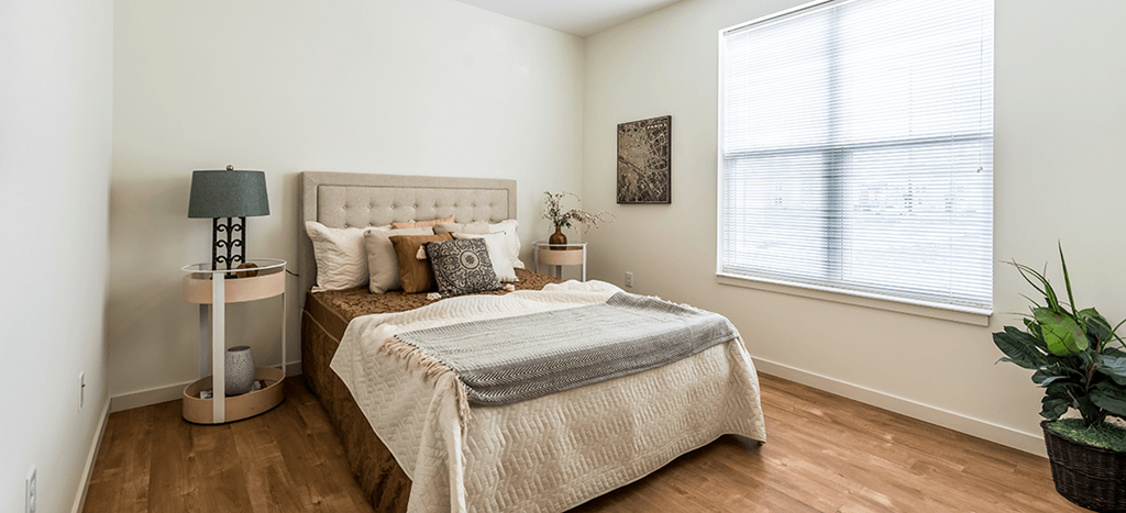 a bedroom with a bed and a large window