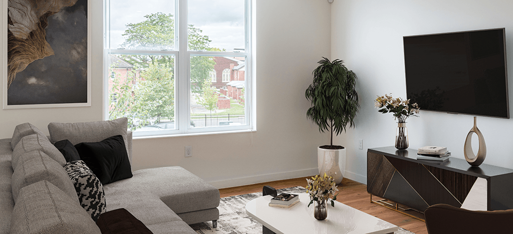 a living room with a couch and a television with a large window