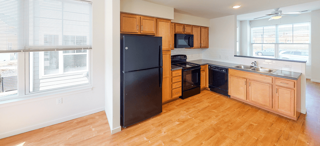 a kitchen with black appliances and wooden cabinets