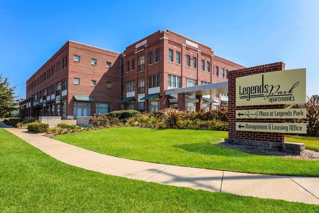 a large brick building with a sign in front of it