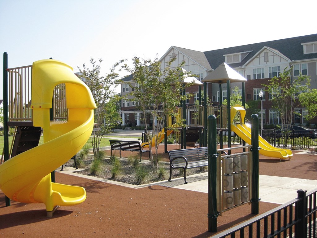 a playground with two yellow slides and benches