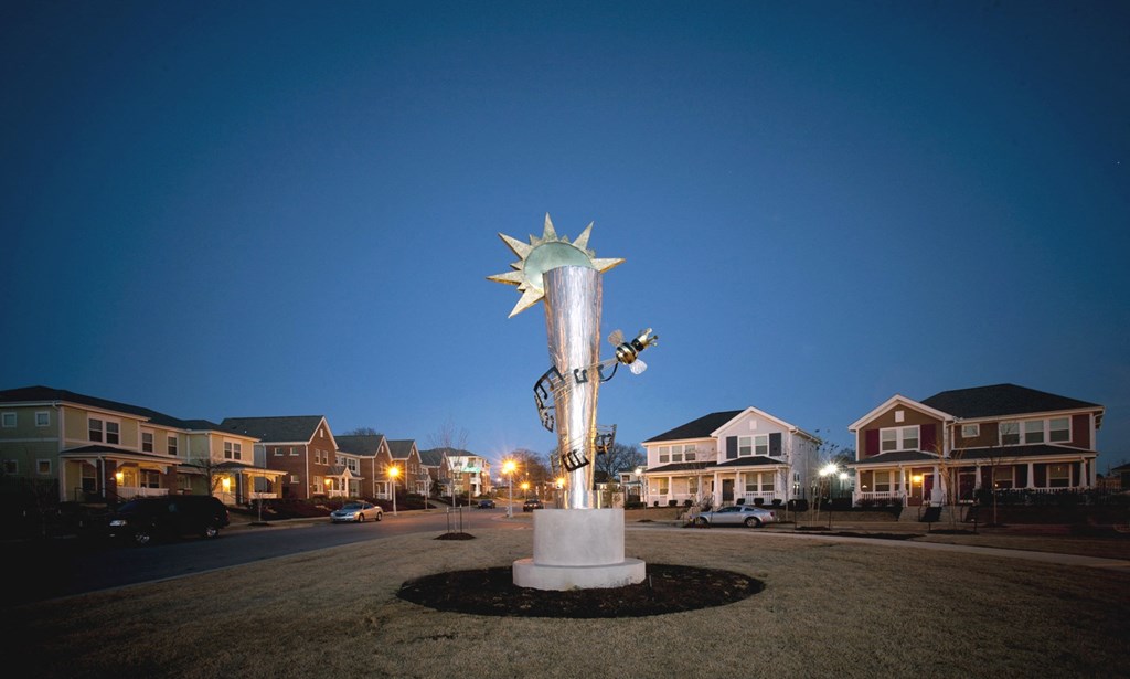 a statue of the sun on a city street at night