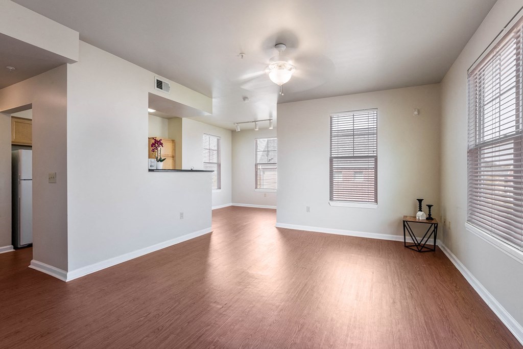 an empty living room with wood flooring and a large window