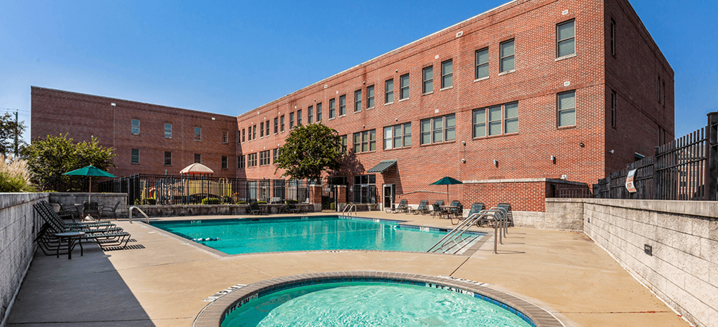 a swimming pool with an apartment building in the background