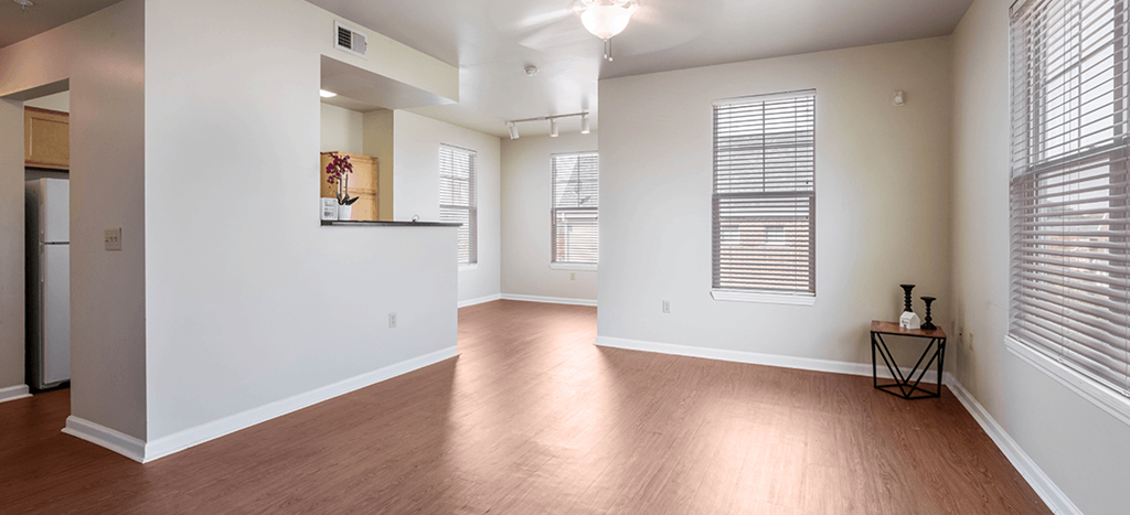 a renovated living room with white walls and wood floors at Legends Park Apartments