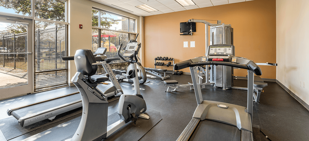 Fitness center at Legends Park Apartments with cardio equipment and weights