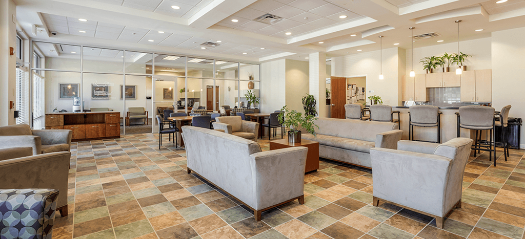 a lobby with couches and chairs and tables in Legends Park Apartments leasing office