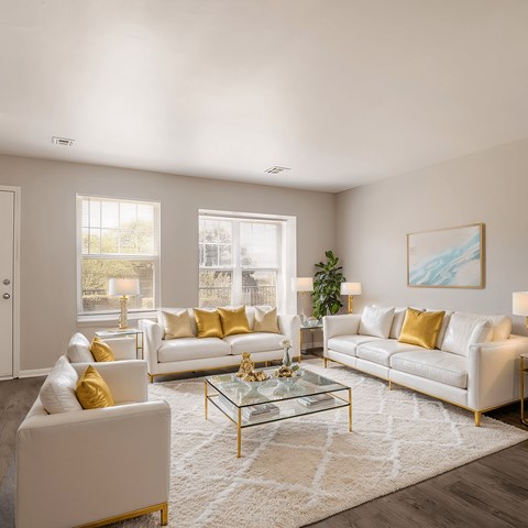 A living room with white furniture and a glass coffee table.