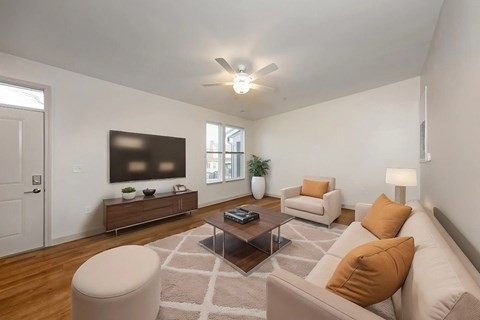 A living room with a brown couch, a white chair, and a wooden coffee table.