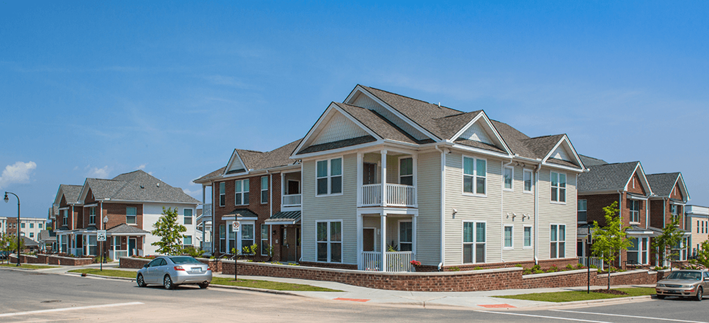 a row of apartment houses on the corner of a street