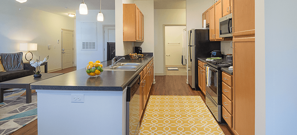 a view of a kitchen with a large counter top and a living room seating area