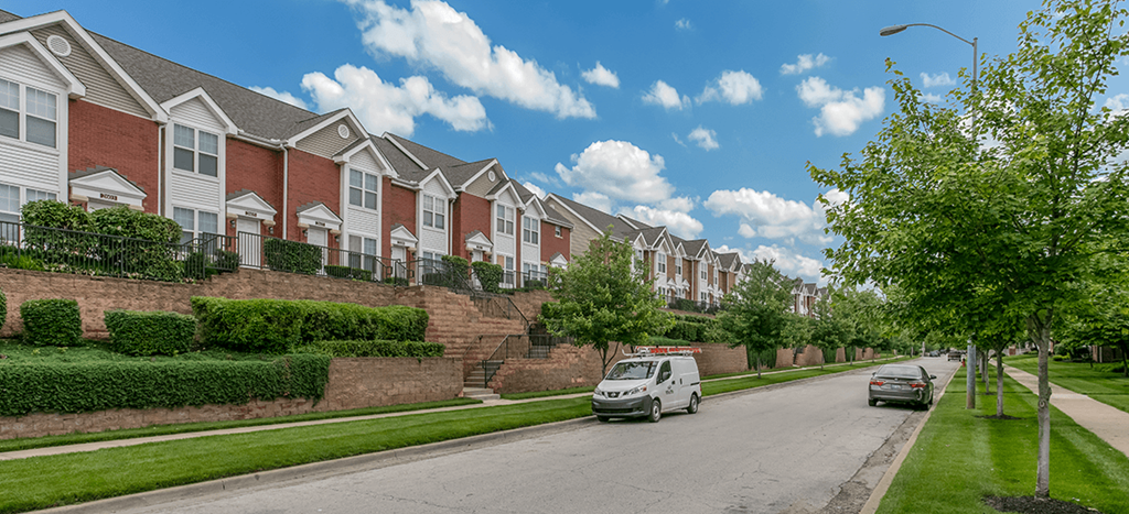 a row of apartment homes on the side of a street