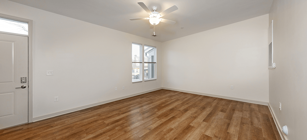 Brown School Lofts interior: an empty living room with wood flooring and a ceiling fan