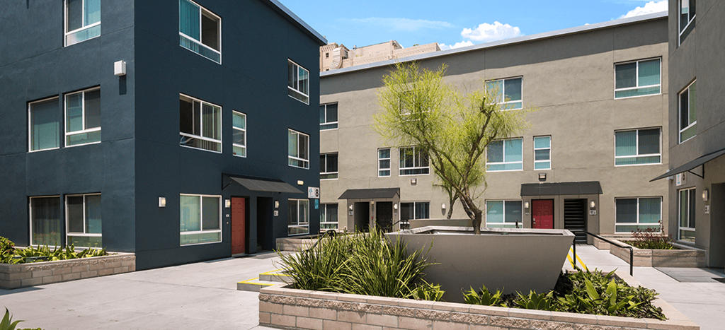 a courtyard with landscaping in front of an apartment building