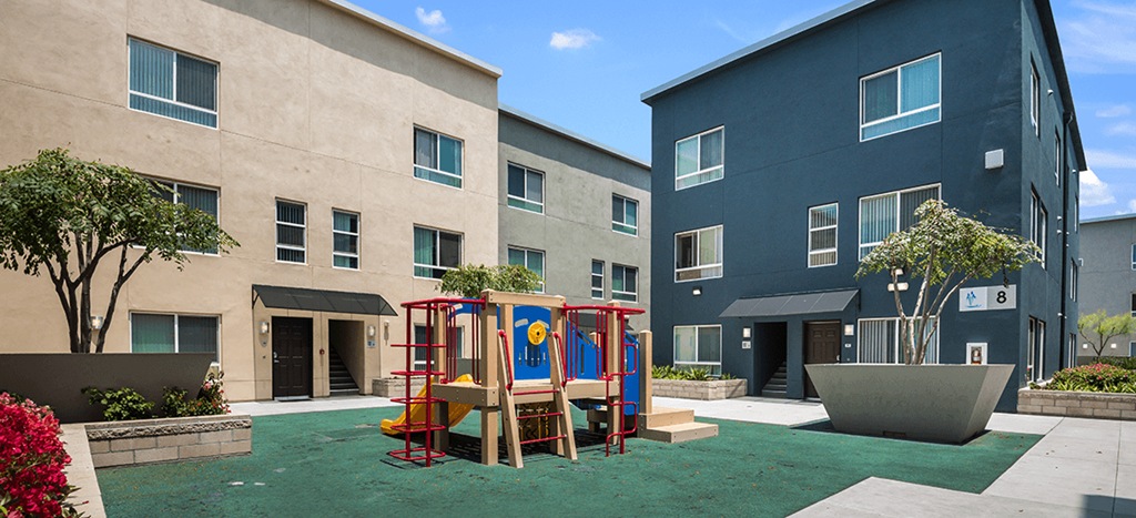 an outdoor play area for children in the courtyard at MacArthur Park Apartments