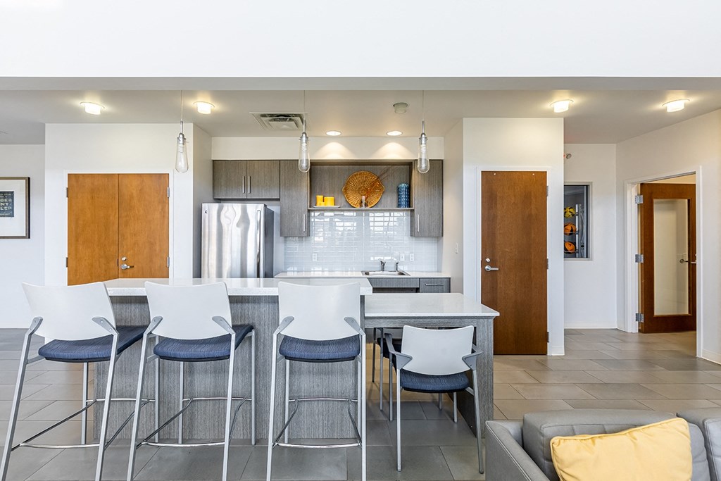 a kitchen with a bar and stools in a community room at Marrero Commons Apartments & Townhomes