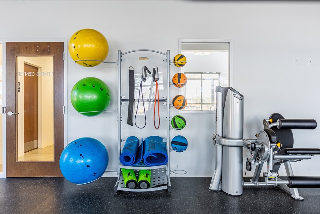 a gym with weights cardio equipment and a mirror at Marrero Commons Apartments & Townhomes